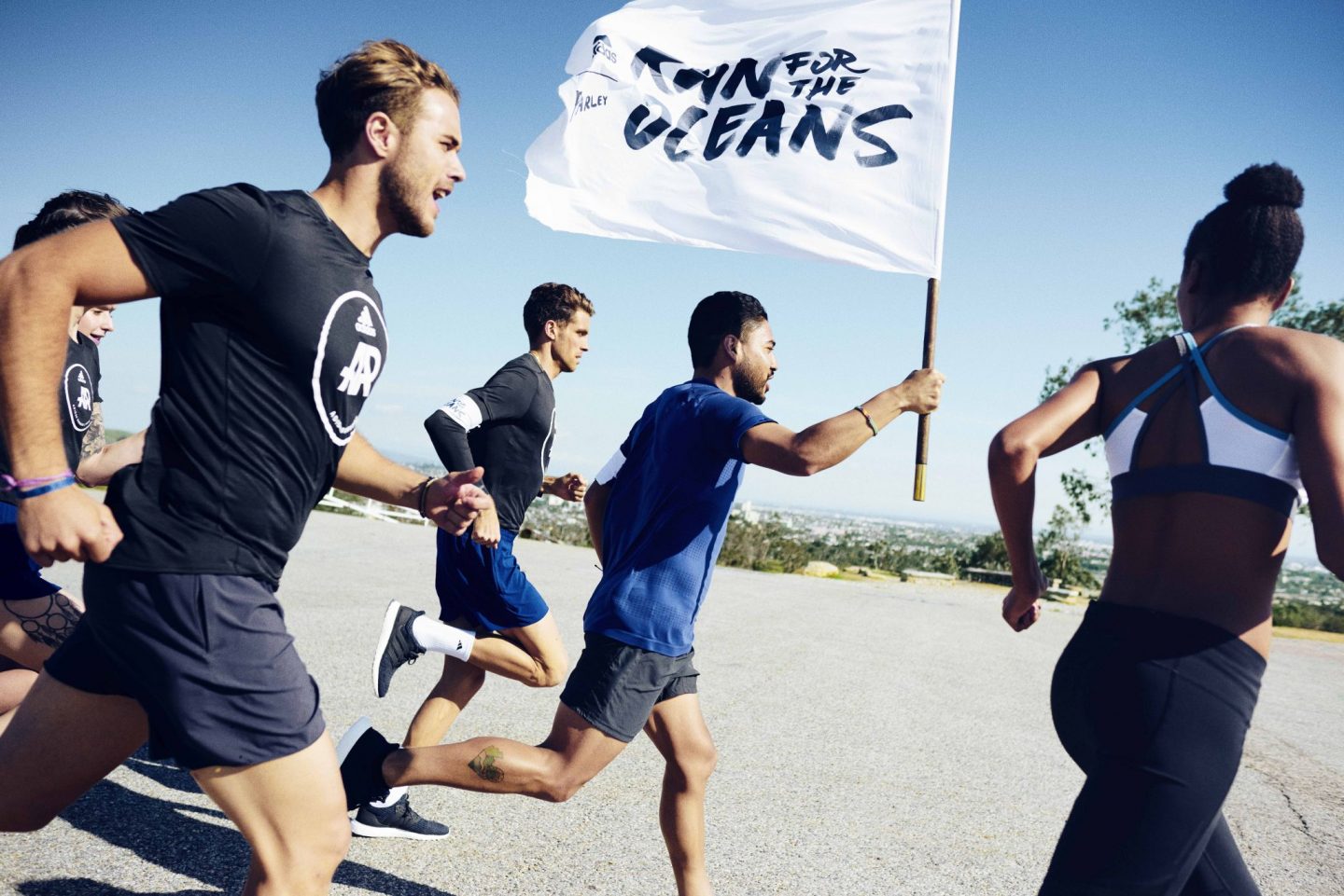 участники благотворительного забега RunForTheOceans в футболках adidas x Parley