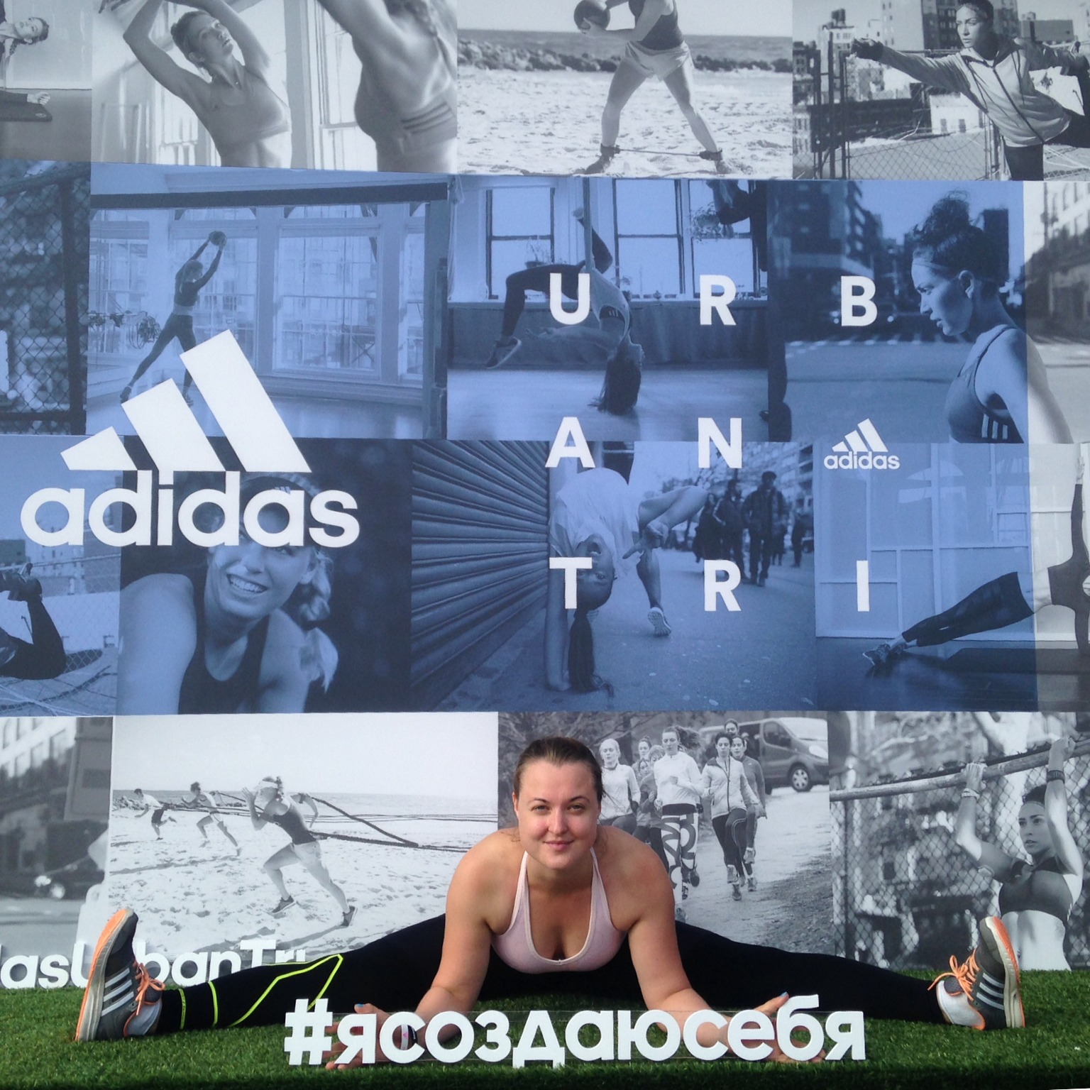Девушка садится на шпагат на фоне баннера adidas Urban Tri